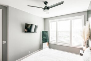 A bedroom with a bed, a ceiling fan, a flat-screen TV, and a window with blinds. - Summer Discount at Nashville City View (Nashville)