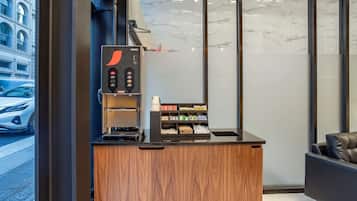 A coffee machine and a counter with various coffee pods and a small display.