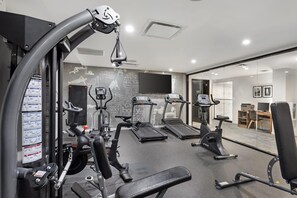 A modern gym with various exercise equipment, including treadmills, an elliptical, and weight machines. - Best Western Plus Soho Hotel (New York)