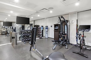 A fitness center with various exercise equipment, including treadmills, weight machines, and a rowing machine. - Best Western Plus Soho Hotel (New York)