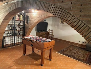 Relax in a spacious room with a high ceiling, exposed brickwork, and a flat-screen TV.