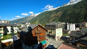 Una cittadina con architettura tradizionale, una piazza centrale e montagne sullo sfondo.