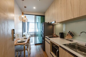 Full-size fridge, microwave, cookware/dishes/utensils, dining tables