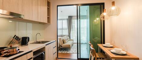 Een moderne keuken met houten kastjes, een spoelbak en een eethoek met een tafel en stoelen.