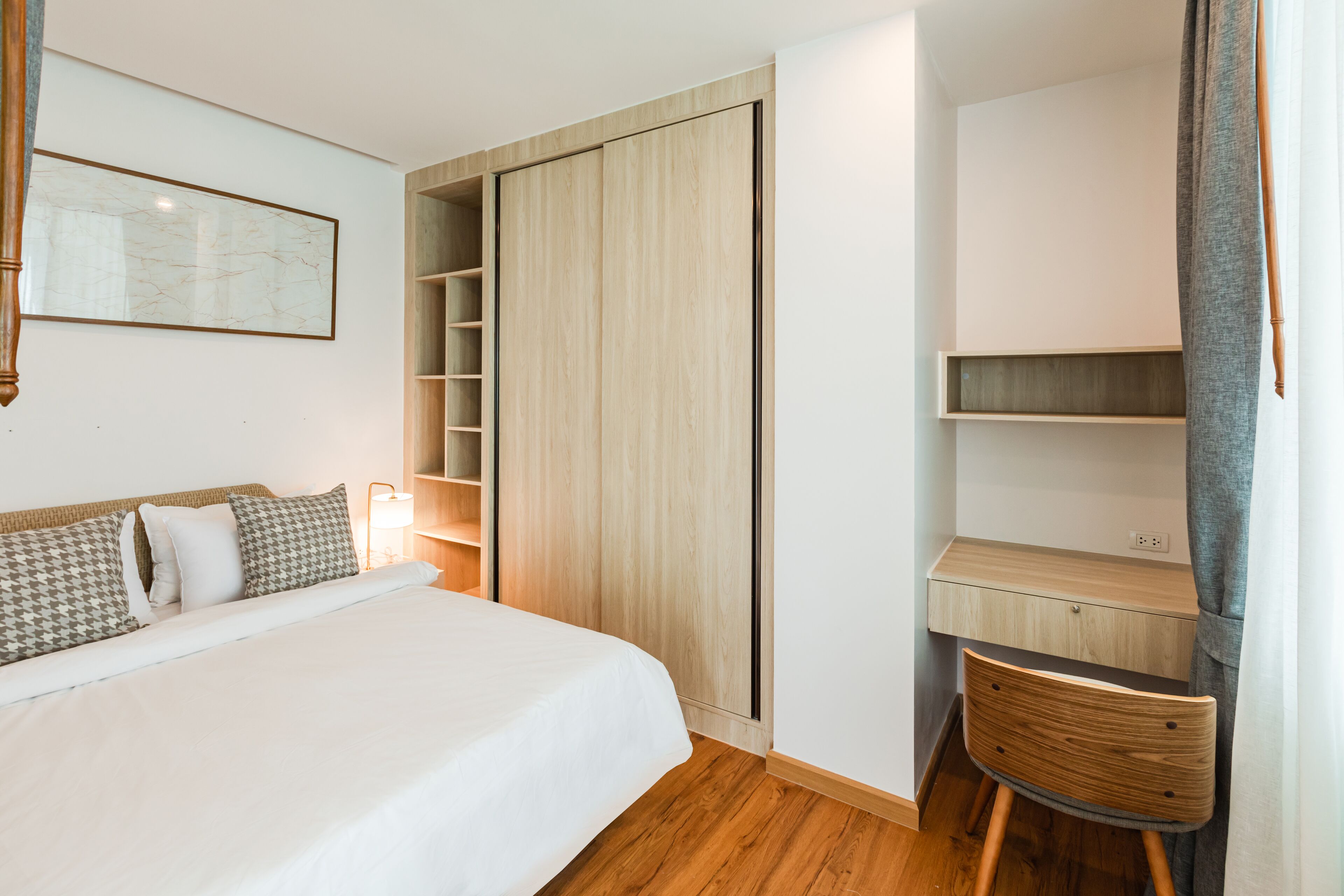 Een slaapkamer met een bed, een bureau en een stoel.