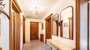 A hallway with wooden doors, a bench, and a mirror. - Apartment "Im Haus Stöckl" with Mountain View, Garden, Terrace & Wi-Fi (Angerberg)