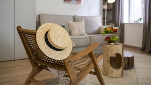 A wicker chair with a straw hat, a wooden stool, and a fruit bowl on a table. - Yellow House Rovinj (Rovinj)