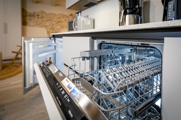 Una cocina moderna con lavavajillas, microondas y cafetera en la encimera.