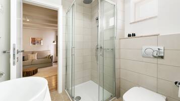 Een moderne badkamer met een douchecabine, een bad en een toilet.