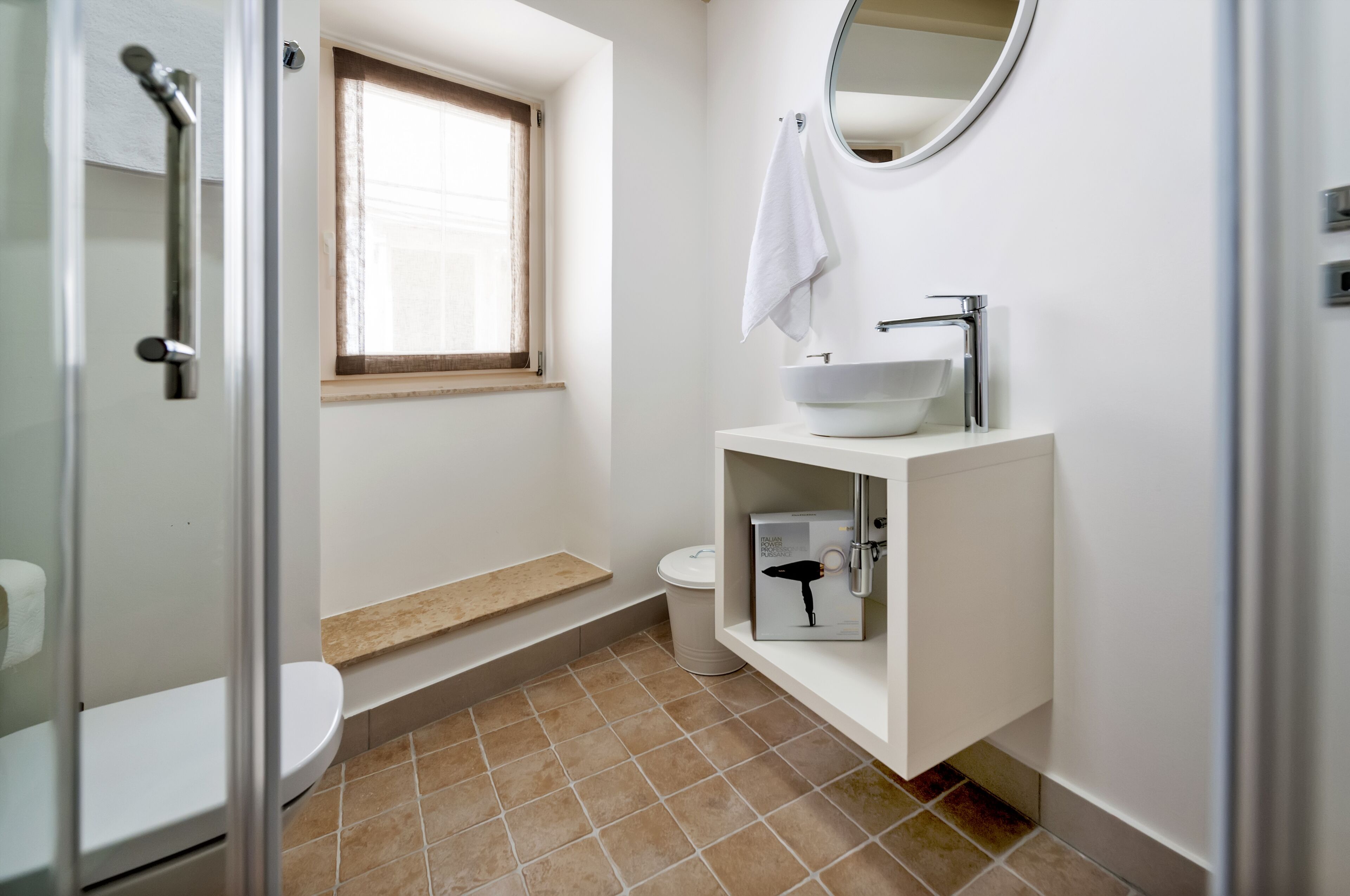 Une salle de bain équipée de toilettes, d’un lavabo et d’une douche.