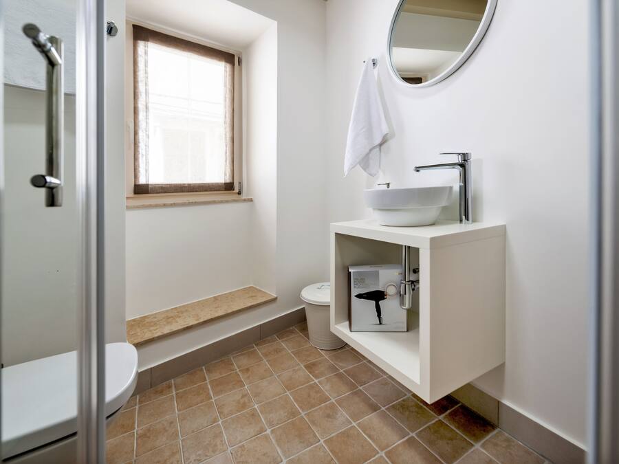 A bathroom with a toilet, sink, and shower.