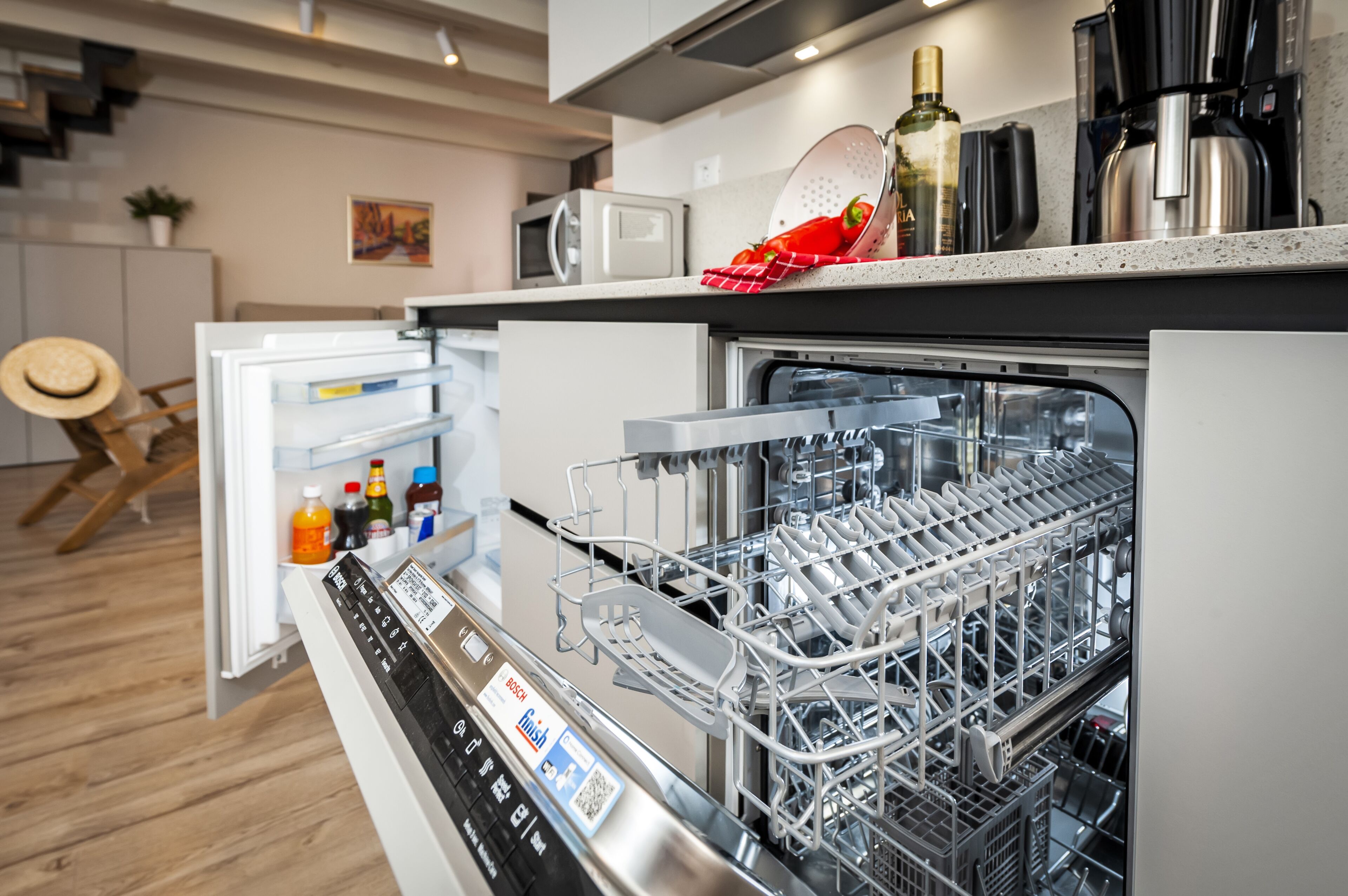 Een moderne keuken met een vaatwasser, een magnetron en een koffiezetapparaat.