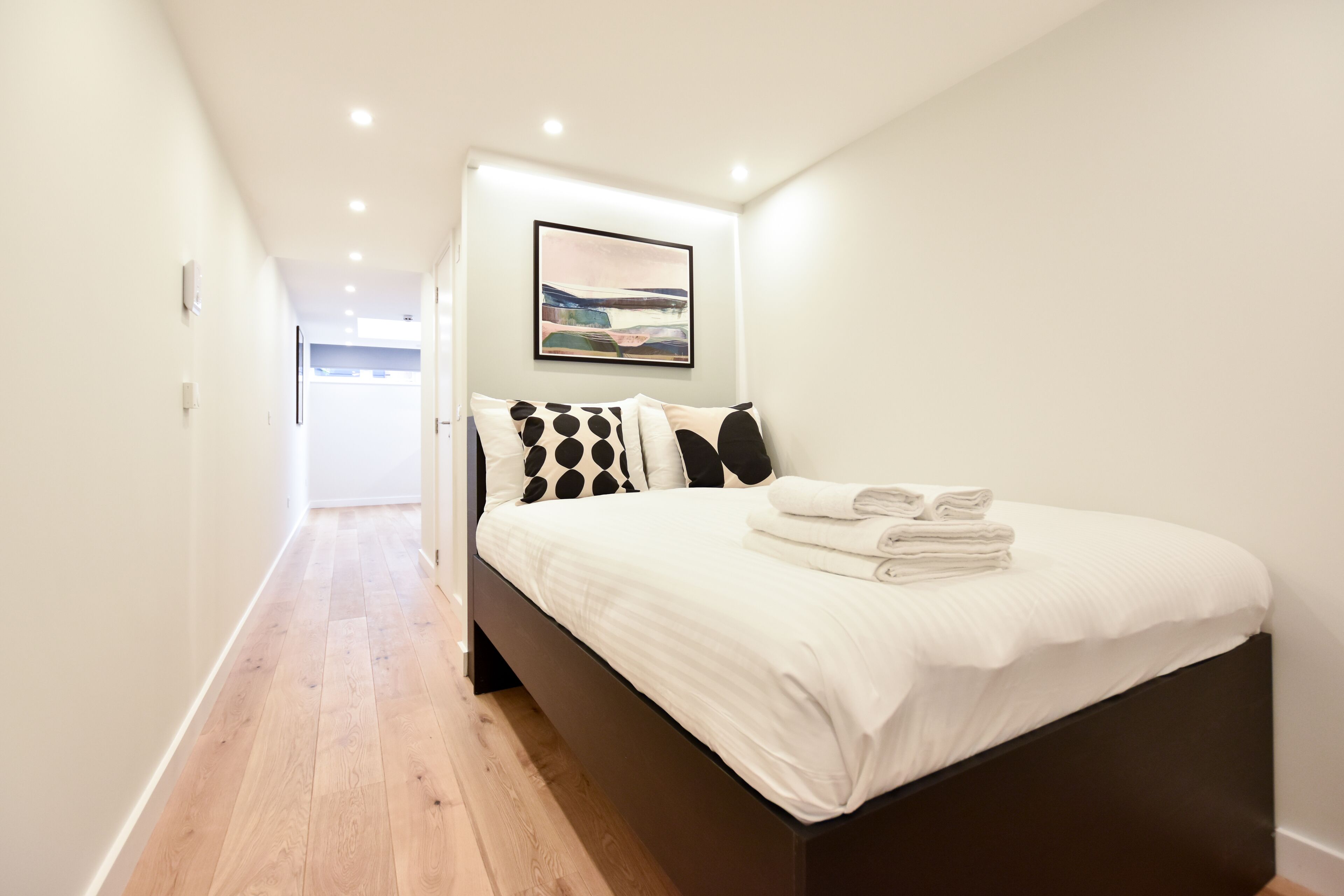 Ein Schlafzimmer mit einem Bett, Kissen und einem Wandbild.
