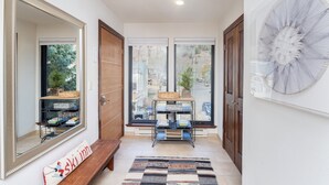 A hallway with a large mirror, a bench, a rug, and a wall-mounted shelf with books and baskets. - 4 BDR Mountain Retreat w/ private deck/hot tub/steps to trail (Telluride)