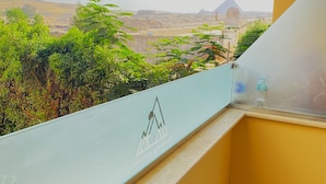 Un balcón con vista a las pirámides y al paisaje circundante.