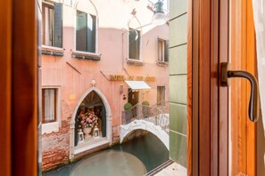 A canal view with a bridge, a pink building with a sign reading 'HOTEL DE CONT,' and a door partially visible.