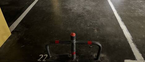 A parking space with a metal barrier and a number "22" on the floor.