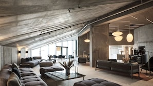 A spacious living area with a large sectional sofa, a coffee table, and pendant lighting.