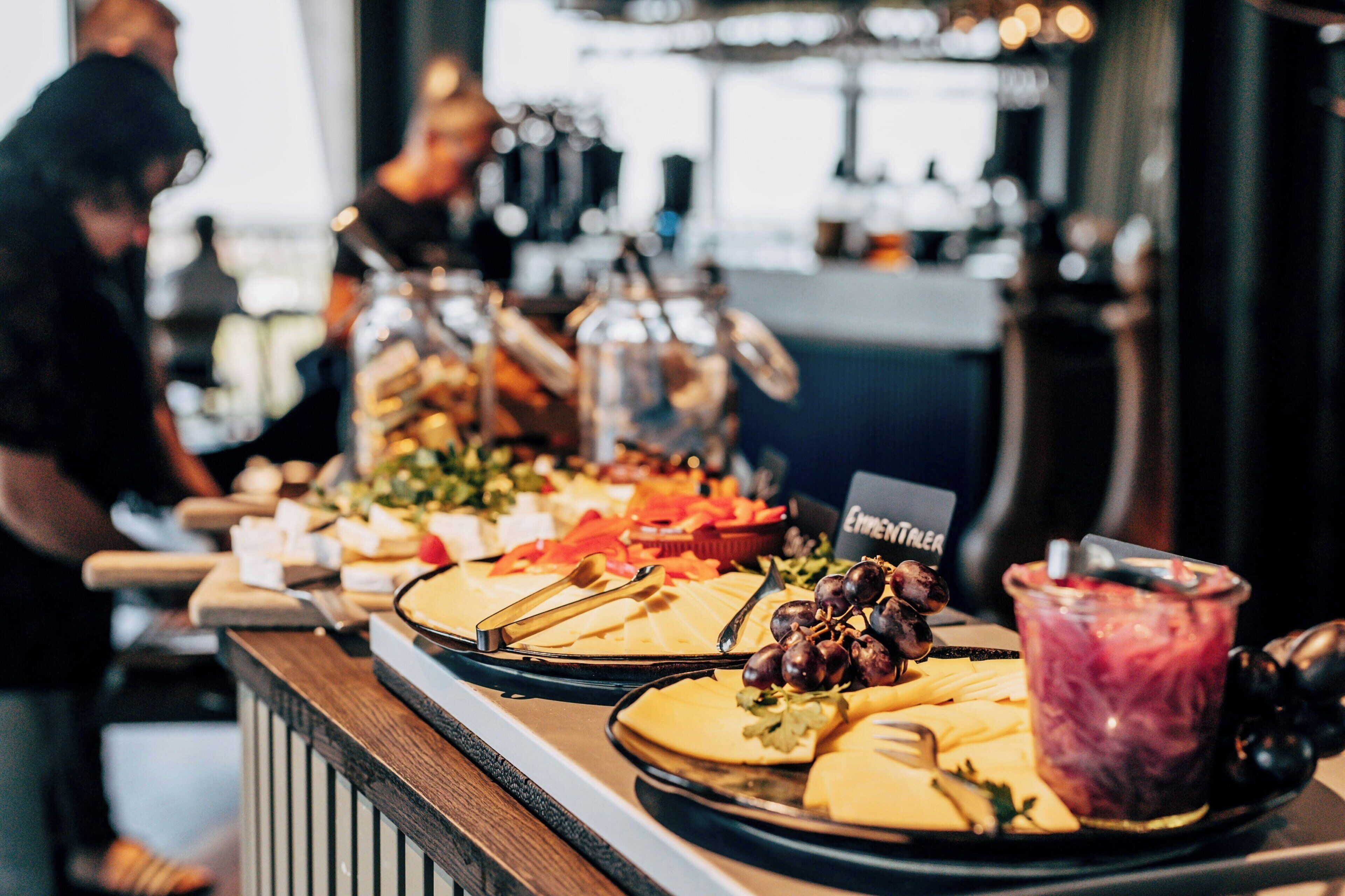 A buffet with various food items and a blender.