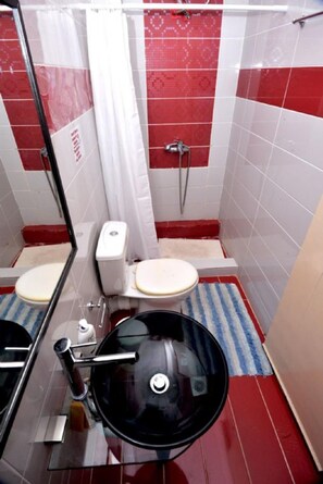 A compact bathroom with a toilet, bidet, and sink.