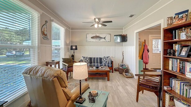 A living room with a sofa, armchair, coffee table, and bookshelf.