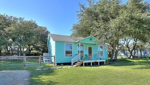 A small, single-story house with a porch and steps leading to the front door.