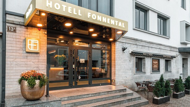 L’extérieur de l’hôtel Fonnental se distingue par son entrée bien visible, un grand pot de fleurs et un espace extérieur aménagé avec des sièges.