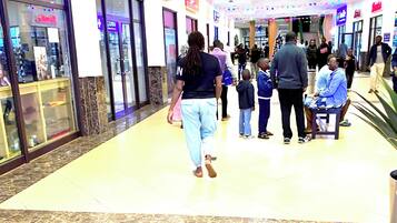 A shopping mall corridor with a 'Centre Opticians' store on the left and a 'Centre Cinemas' on the right.
