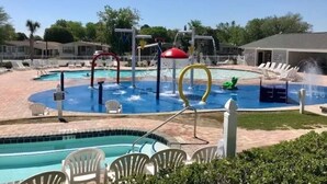 A swimming pool area with multiple pools, water features, and lounge chairs. - Private beach access! 2 Bedroom, 2 Full Bath Cottage with many amenities!  (Surfside Beach)