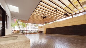 An indoor space with a wooden ceiling, a dark floor, and a view of buildings outside. - The Snooze Hotel Marine Parade (Singapore)