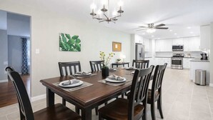 A modern dining room with a dark wooden table set for six, surrounded by chairs. - *The Comfy King Ranch*King Bed Suite*Fast Wi-Fi (Worth)