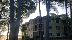 A multi-story building with a flat roof and large windows, surrounded by trees. - Effy's Sunset Serenity Hideaway (Sunset Beach)