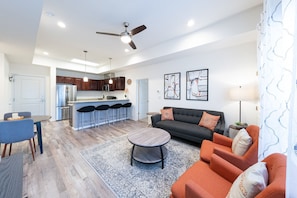 A modern apartment with a kitchen, dining area, and living room.