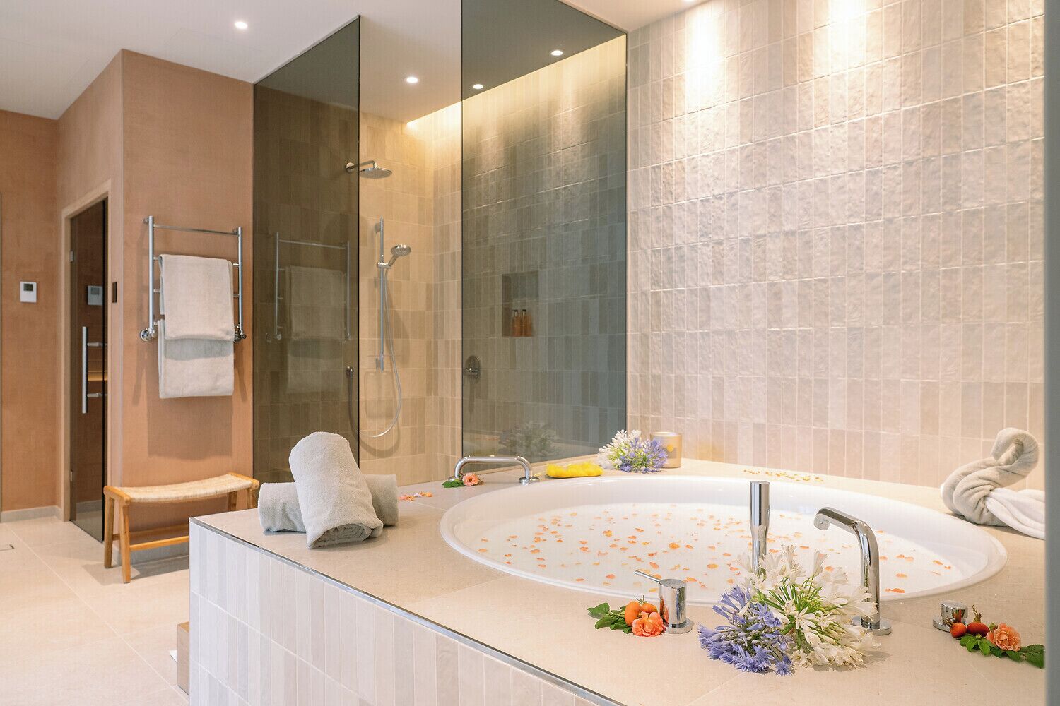 Une salle de bain moderne dotée d’une grande baignoire, d’un espace douche et d’un meuble-lavabo avec un miroir.