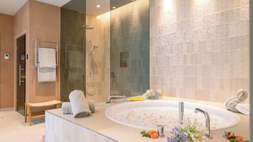 Une salle de bain moderne dotée d’une grande baignoire, d’un espace douche et d’un meuble-lavabo avec un miroir.