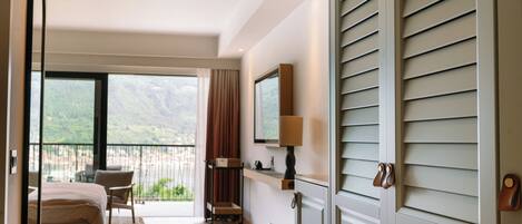 Una habitación de hotel moderna con balcón, cama, escritorio y una silla.
