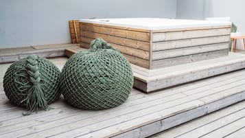 Ett trädäck med ett område för avkoppling, inklusive en träbänk och ett massagebord.