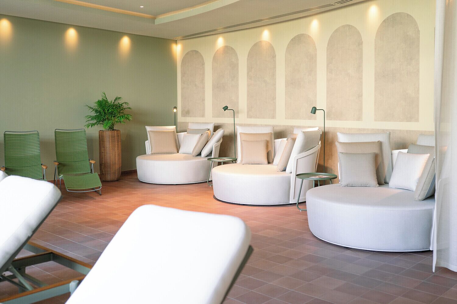 A spa area with multiple seating options, including chairs and sofas, and a large potted plant.