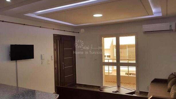 A modern living room with a television, a sofa, and a dining area. - Nice apartment in soviva (حمام سوسة)