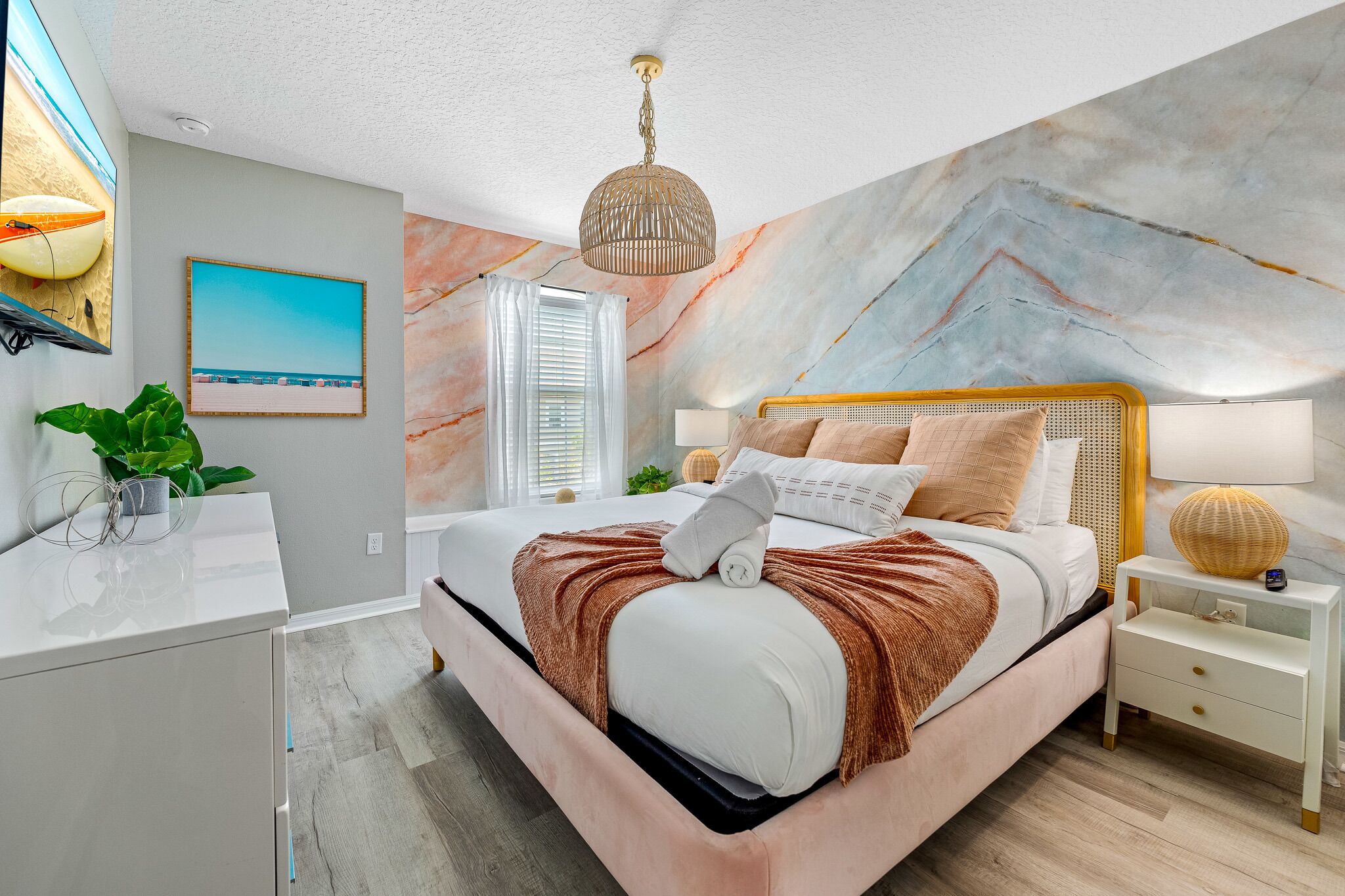 Une chambre moderne avec un grand lit, une lampe de chevet et une fresque murale.