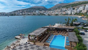 A resort with a pool, beach, and city view. - Grand Hotel Saranda (Sarandë)