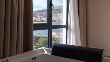 Una habitación con un ventanal grande, una bañera y vistas a la ciudad.