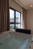 Una habitación con un ventanal grande, una bañera y vistas a la ciudad.