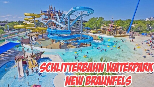 Un parc aquatique doté de nombreux toboggans et de plusieurs piscines, notamment un grand toboggan bleu et un plus petit toboggan jaune.