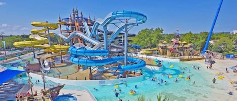 A water park with multiple slides and pools, including a large blue water slide and a smaller yellow one.