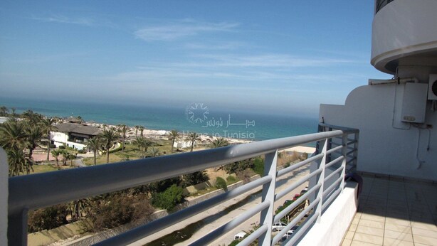 A balcony with a view of the sea and buildings. - Superb apartment in residence monaco, sousse (sousse)