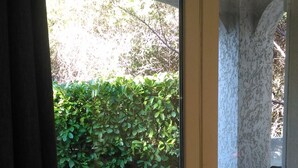A glass door leading to an outdoor patio area with a table and two chairs. - BED AND BREAKFAST, private 1st floor in villa  (saint raphael)