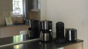 A modern kitchen with a black countertop, stainless steel appliances, and a wall clock. - BED AND BREAKFAST, private 1st floor in villa  (saint raphael)