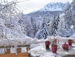A wooden table with red cups and a teapot on a balcony overlooking a snowy mountain landscape. - SKI IN SKI OUT CHALET SLEEPS 14 JACUZZI MOUNTAIN VIEW VARS LES CLAUX (Vars)