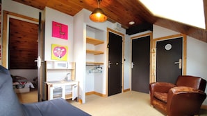 A room with a bed, a desk, a chair, and a wardrobe.